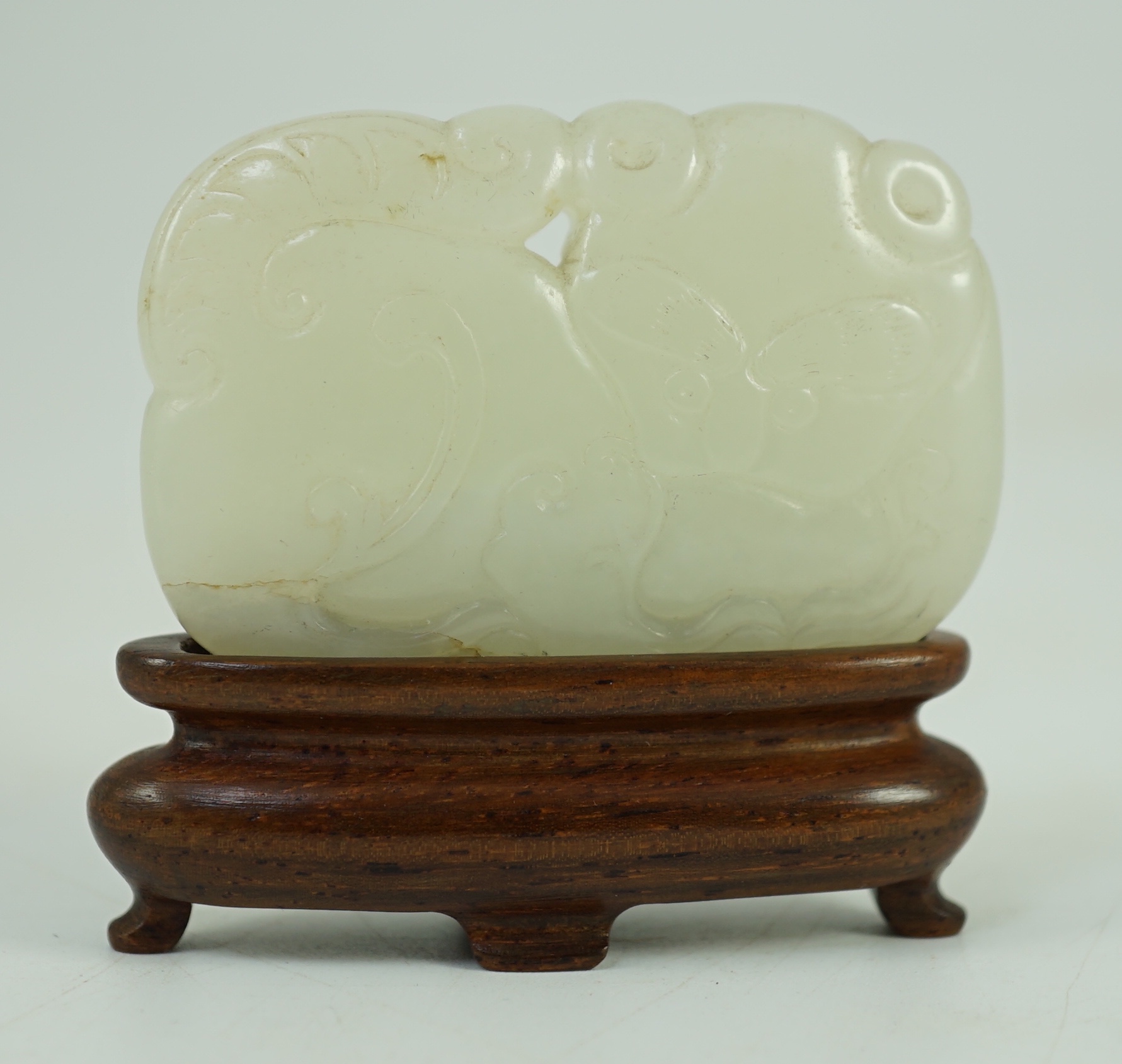 A Chinese white jade ‘tiger and dragon’ plaque, 18th/19th century 5.1 cm wide, wood stand